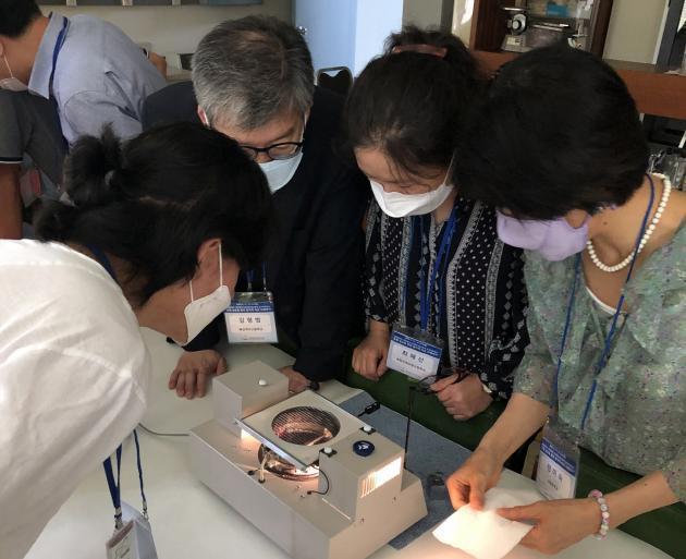 지난해 한국원자력연구원이 실시한 직무연수 과정에 참석한 중고교 교사들이 안개상자 체험을 통해 방사선을 관찰하고 있다.