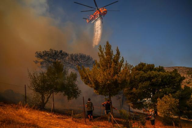 6일(현지시간) 아테네 인근 화재 지역에 물을 투하하는 소방 헬기. 제공=연합뉴스