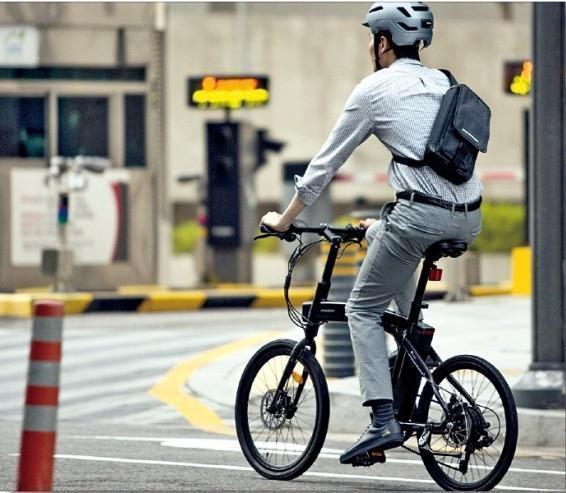 전기자전거 사용자가 전기자전거를 타고 출근하고 있다.
