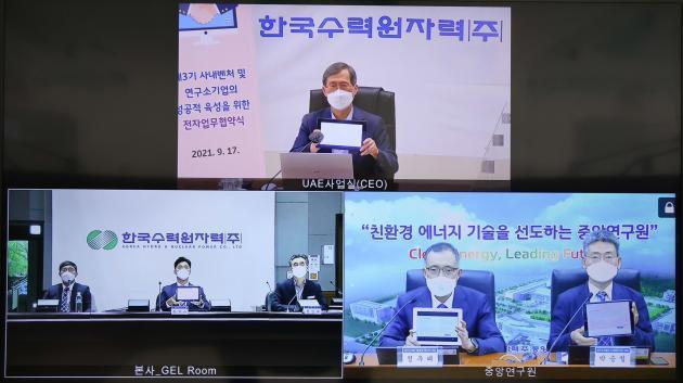 한국수력원자력이 17일 '연구소기업 설립을 위한 기본합의서 서명식'을 비대면으로 진행했다. 정재훈 한수원 사장(위쪽)이 전자서명으로 서명한 뒤 사진 촬영을 하고 있다.