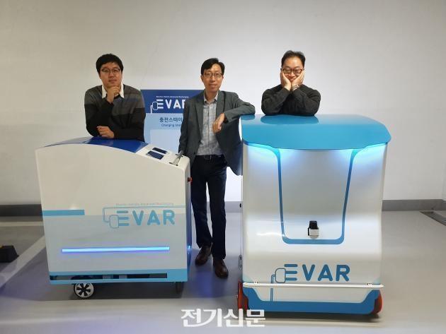 지난 2019년 본지 인터뷰에서 이훈 대표(가운데), 신동혁 이사(오른쪽)가 에바의 수동 카트형과 자율주행 이동형 전기차 충전기와 함께 찍은 사진.