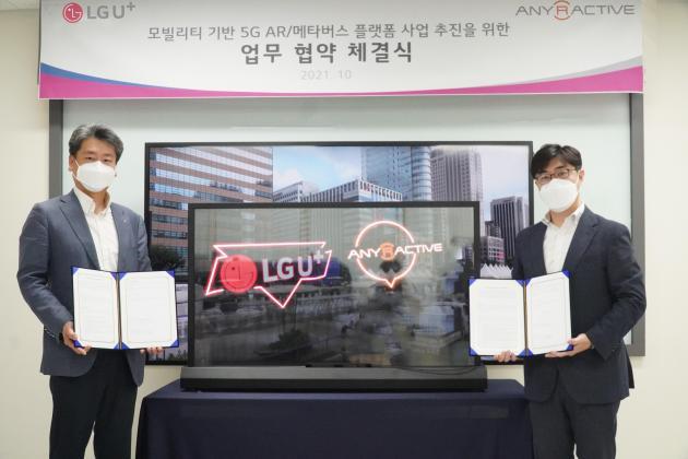 서울 성동구 애니랙티브 사옥에서 열린 모빌리티 기반 업무협약 체결식에서 강종오 LG유플러스 스마트시티사업담당 상무(왼쪽)와 임성현 애니랙티브 대표가 투명 OLED 앞에서 기념촬영을 하고 있다.