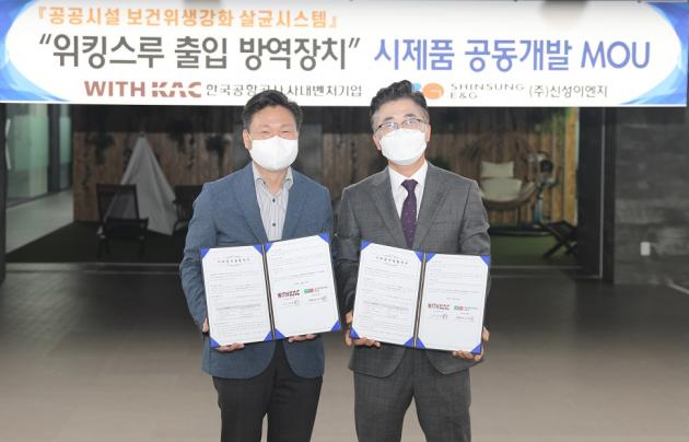(왼쪽부터)김동권 신성이엔지 이사와 김진오 위드케이에이씨 대표가 워킹스루 출입방역장치 개발 관련 MOU를 체결한 뒤 기념촬영을 하고 있다.
