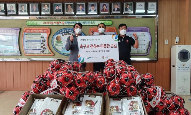 김용진 GS파워 지역협력팀 처장(가운데)과 김성남 부천FC 단장(오른쪽)이 부천초등학교에 축구사인볼과 기념품을 전달하고 기념촬영을 하고 있다.