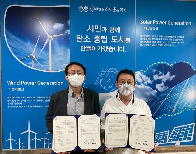 김성철 파란에너지 대표(왼쪽)와 박민관 광명시 기후에너지과장이 업무협약 후 협약서를 펼쳐 보이고 있다.