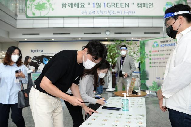 KOTRA 직원들이 ‘1일 1Green’ 친환경 실천을 서약하고 약속나무에 서약카드를 걸고 있다.