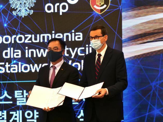 18일(현지시간) 폴란드 스탈로바볼라 제슈프기술공대에서 열린 투자협약식에서 이완재 SKC 사장(왼쪽)이 마테우슈 모라비에츠키 폴란드 총리와 함께 협약을 체결하고 있다. 