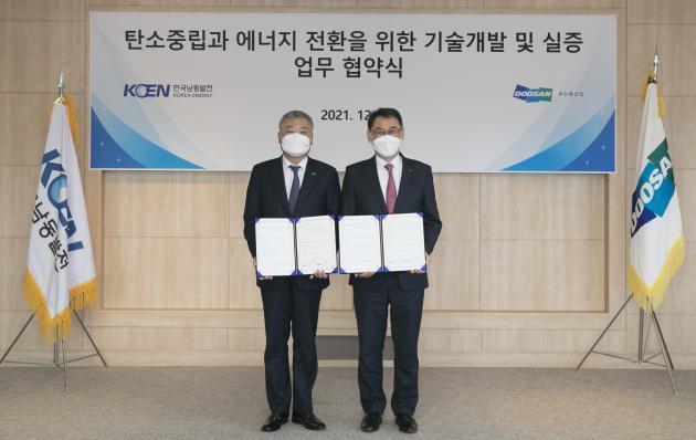 김회천 남동발전 사장(왼쪽)과 정연인 두산중공업 사장이 업무협약을 체결한 뒤 기념촬영을 하고 있다.