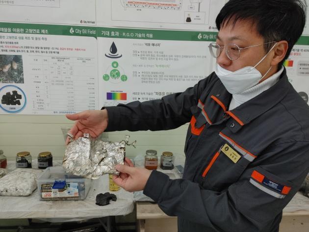 함동현 도시유전 사업총괄본부장이 과자봉지에서 플라스틱 성분만 추출한 뒤 남은 알루미늄박을 보여주고 있다.