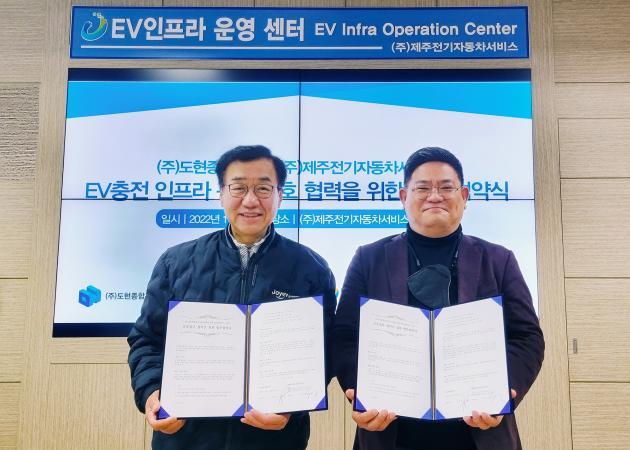 이규제 제주전기자동차서비스 대표(왼쪽)과 김형진 도현종합건설 대표가 업무협약서에 서명을 하고 기념사진을 찍고 있다.