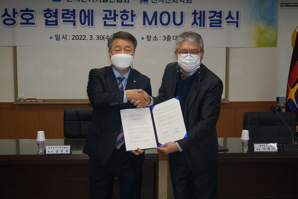 김선복 전기기술인협회 회장(왼쪽)과 이택기 전력전자학회 회장이 서명을 마친 협약서를 상호 교환하며 악수를 나누고 있다.