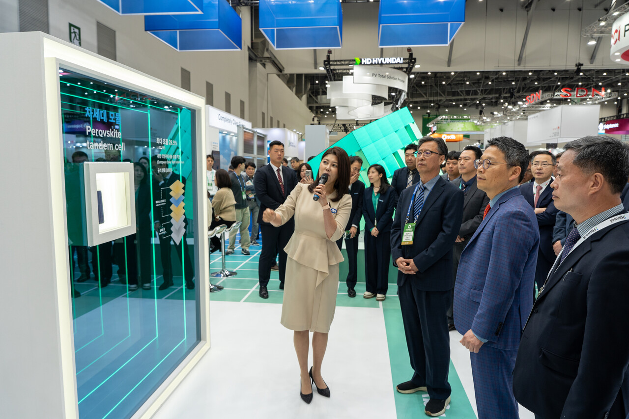 정경록 산업통상자원부 재생에너지정책관(앞열 오른쪽 두 번째), 김병곤 경상북도 동해안전략산업국장(앞열 오른쪽 세 번째) 등이 국제그린에너지엑스포에 차려진 한화큐셀 부스에서 차세대 태양전지 모듈을 살펴보고 있다. [사진=김진후 기자.]