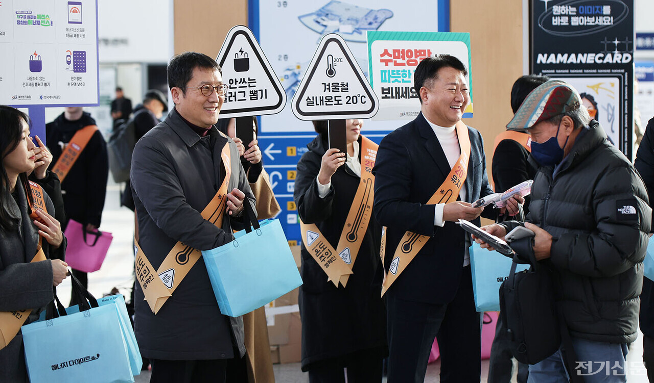 12일 서울역 대합실에서 노용호 전기협회 부회장(오른쪽)과 이상훈 에너지공단 이사장이 에너지절약’ 거리캠페인을 진행하며 시민들에게 수면양말을 나눠주고 있다. 