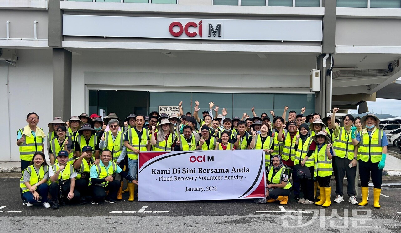 OCI그룹 임직원 100여명이 말레이시아 빈툴루 수해복구 현장에서 기념촬영을 하고 있다. [제공=OCI홀딩스]