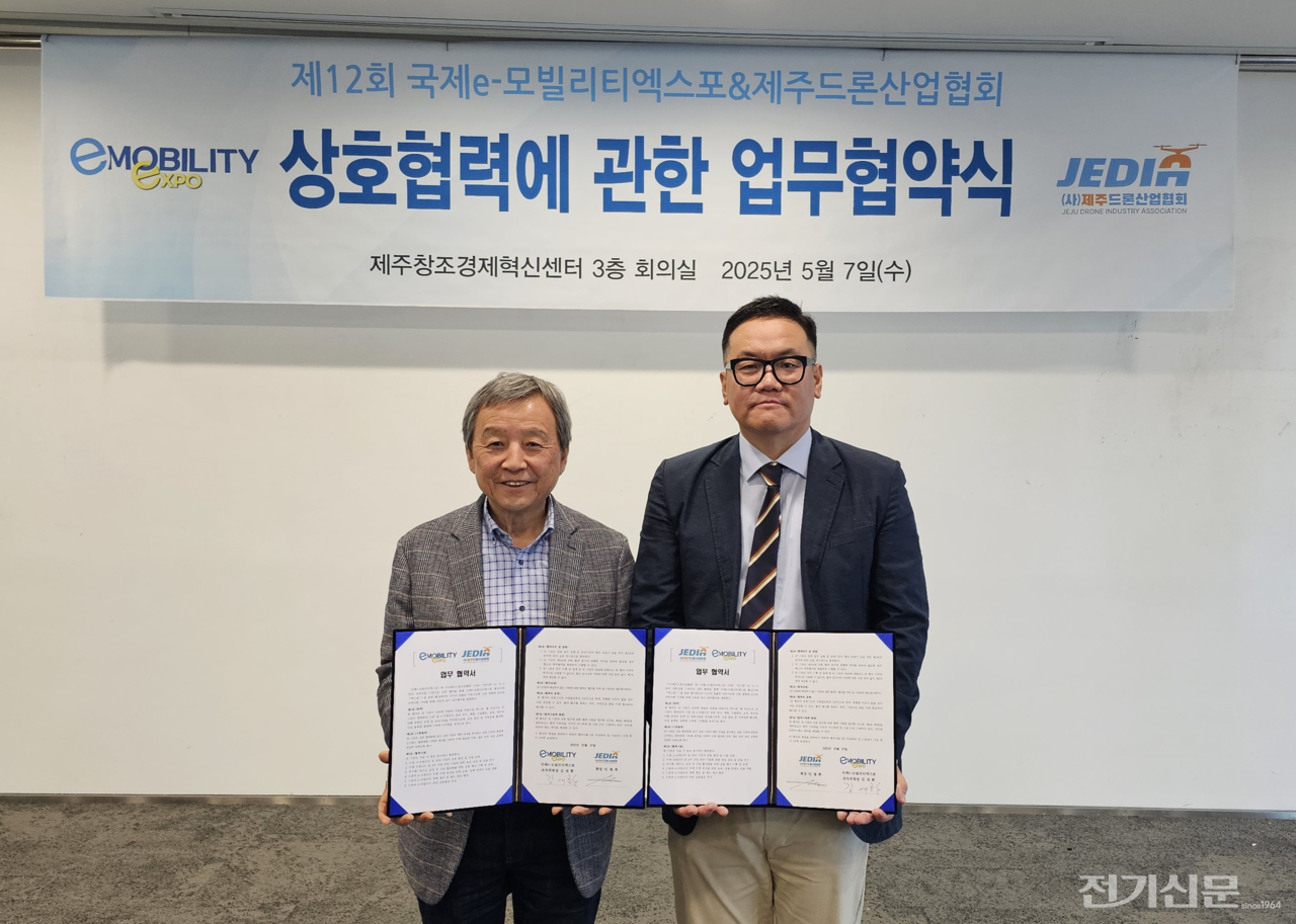 김대환 국제e-모빌리티엑스포 공동조직위원장(왼쪽)과 안광희 제주드론산업협회 회장이 업무협약을 체결하고 기념 사진을 찍고 있다. [사진=국제e-모빌리티엑스포 조직위]