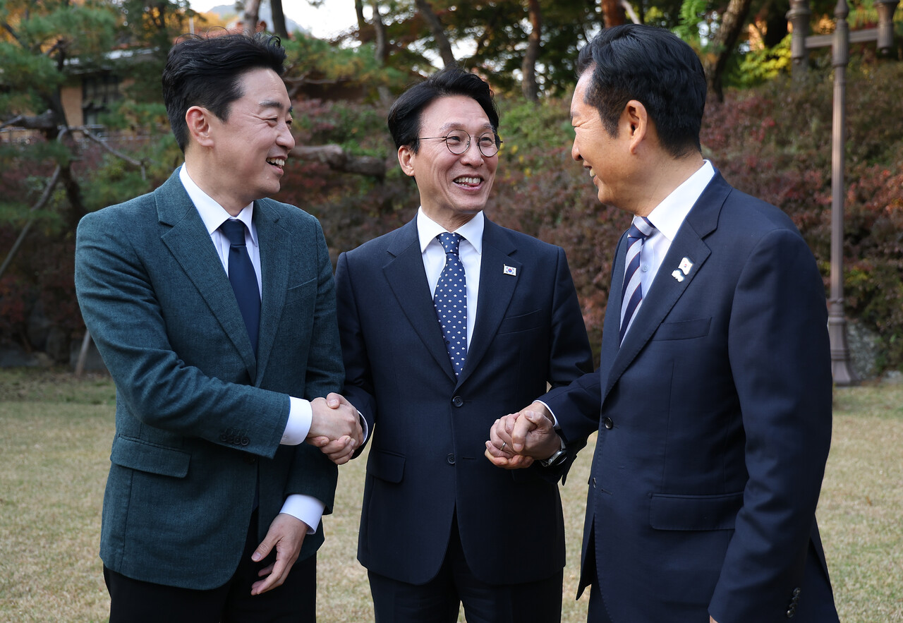 김민석 국무총리(가운데)가 9일 서울 종로구 총리공관에서 열린 고위당정협의회에서 강훈식 대통령 비서실장(왼쪽), 더불어민주당 정청래 대표와 손을 잡고 있다. [사진=연합뉴스]
