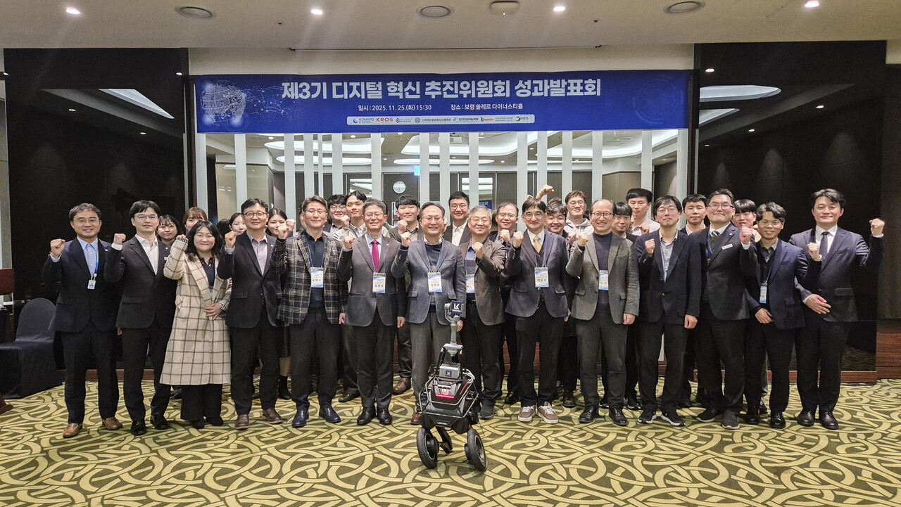 디지털 혁신 추진위원회 성과발표회 참석자들이 지난 10월 ‘2025 중부발전 지능형 로봇 챌린지’ 대회에서 1위를 차지해 대통령상을 받은 ‘수소 화합물 감지 2족 보행 로봇’과 함께 기념촬영을 하고 있다. [사진=중부발전]