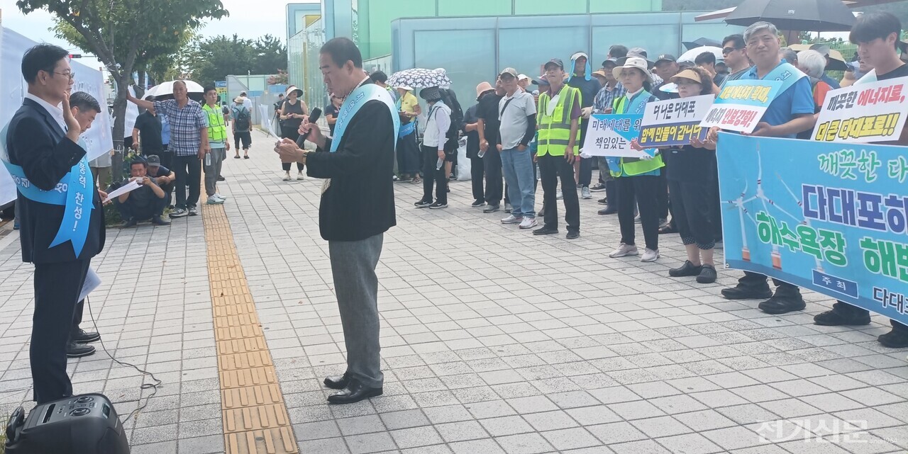 서왕조 다대지역발전추진위원장이 다대포해수욕장에서 열린 '다대포 지역발전 및 환경정화활동의 날' 행사에서 해상풍력 발전사업 지지 결의문을 낭독하고 있다. [사진=윤재현 기자]