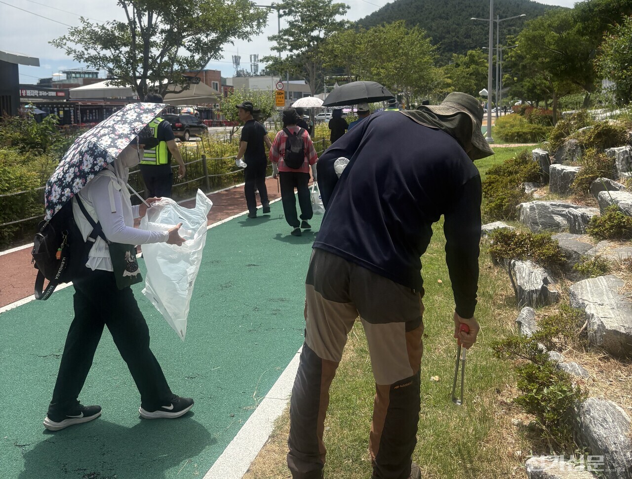 다대지역발전추진위원회가 25일 부산 다대포해수욕장 해변공원 일대에서 '다대포 지역발전 및 환경정화활동의 날' 행사를 개최한 가운데 주민들이 집게와 수거봉투를 들고 쓰레기를 수거하는 등 환경정화활동을 펼치고 있다.